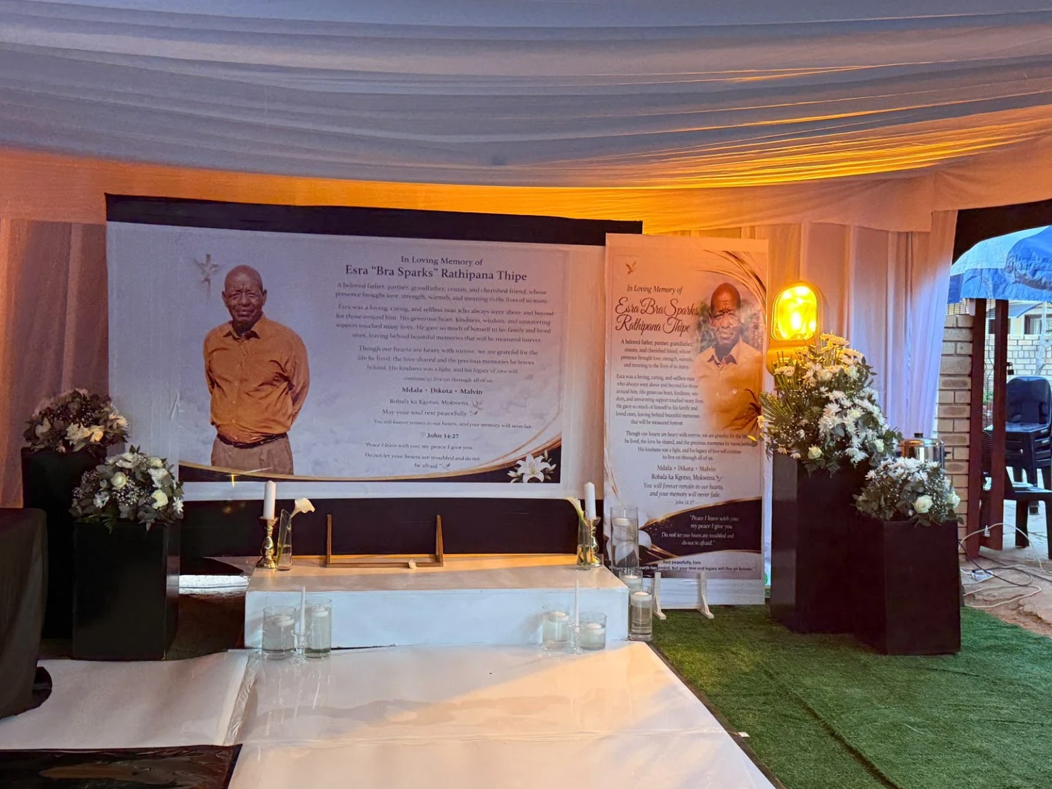 Thoughtfully composed remembrance displays, floral arrangements, candles and soft lighting at a memorial gathering.