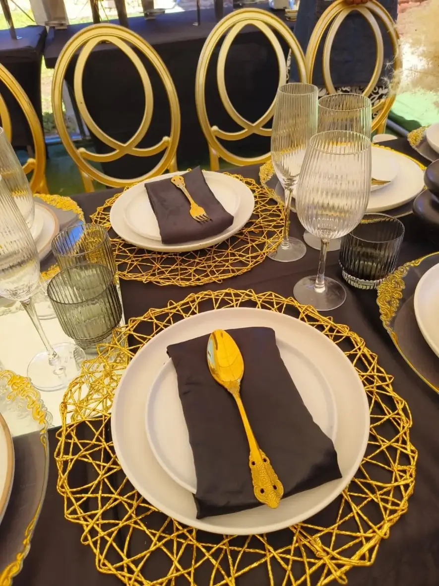 Black & Gold Place Settings. Contrasting black linens and sculptural gold touches deliver statement dining.