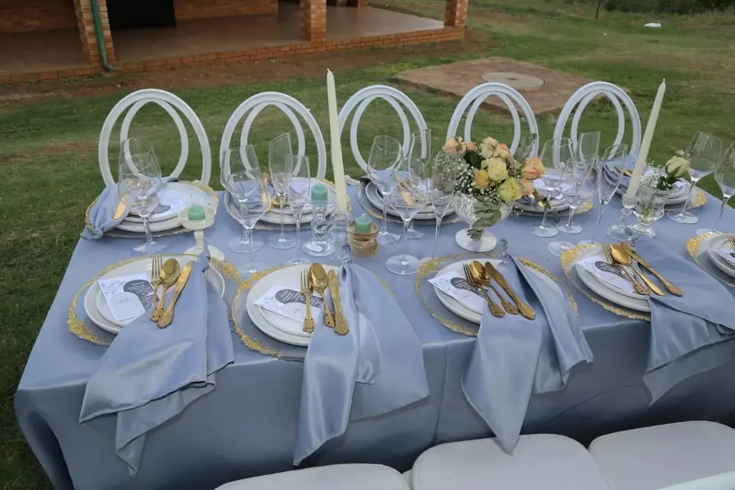 Silver Garden Reception. Silver draping, white seating and refined gold accents create an atmosphere of understated elegance.